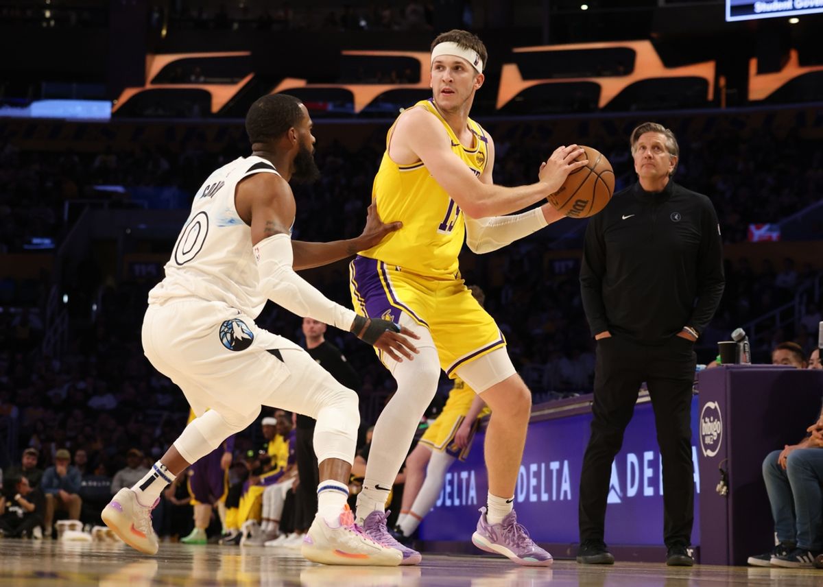 Feb 27, 2025; Los Angeles, California, USA; Los Angeles Lakers guard Austin Reaves (15) looks to pass against Minnesota Timberwolves guard Mike Conley (10) during the second quarter at Crypto.com Arena. Mandatory Credit: Jason Parkhurst-Imagn Images