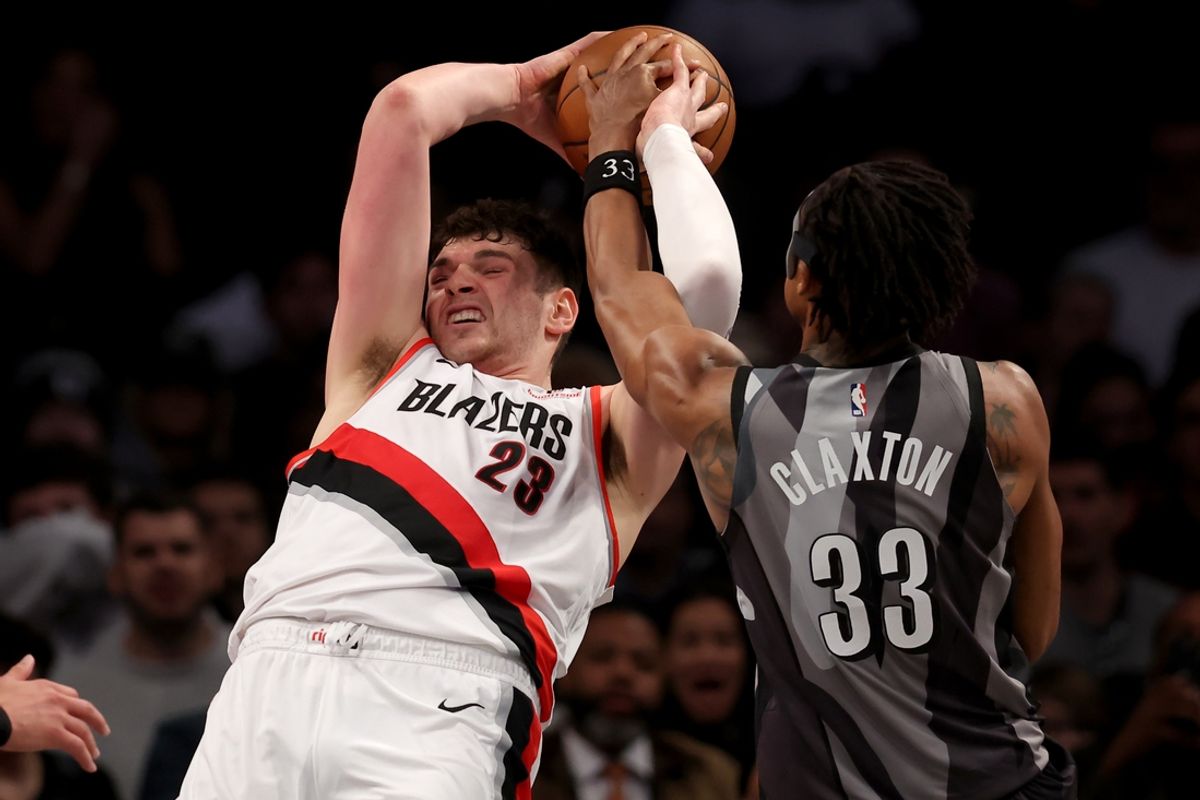 Feb 28, 2025; Brooklyn, New York, USA; Portland Trail Blazers center Donovan Clingan (23) fights for a rebound against Brooklyn Nets center Nic Claxton (33) during the second quarter at Barclays Center. Mandatory Credit: Brad Penner-Imagn Images