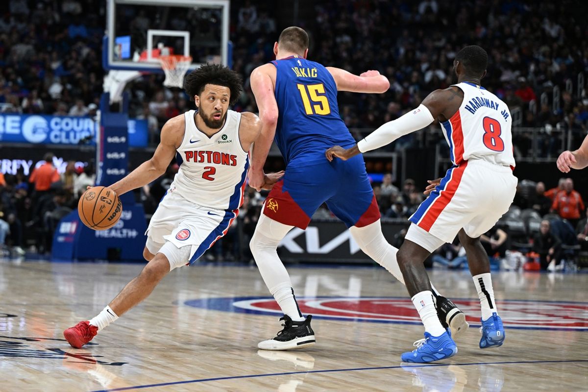 Feb 28, 2025; Detroit, Michigan, USA; Detroit Pistons guard Cade Cunningham (2) drives around Denver Nuggets center Nikola Jokic (15) in the third quarter at Little Caesars Arena. Mandatory Credit: Lon Horwedel-Imagn Images