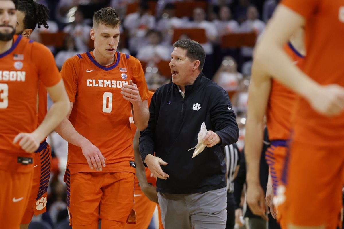 Mar 1, 2025; Charlottesville, Virginia, USA; Clemson Tigers head coach Brad Brownell (center) talks to Tigers center Viktor Lakhin (0) during half time after the first half against the Virginia Cavaliers at John Paul Jones Arena. Mandatory Credit: Amber Searls-Imagn Images