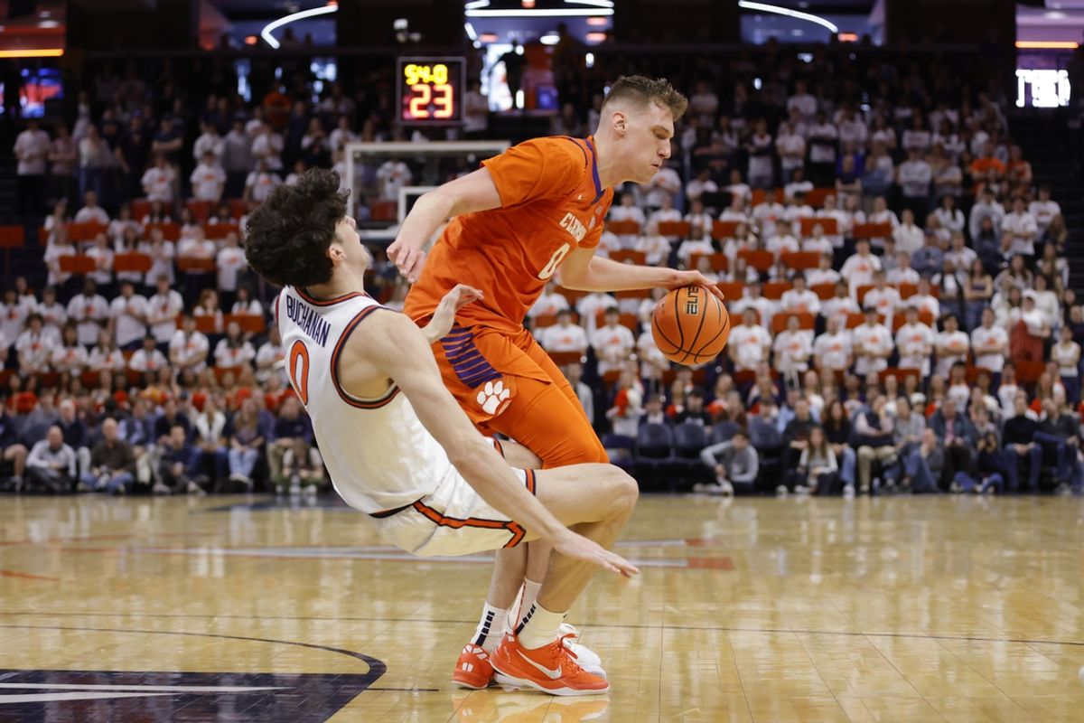 Mar 1, 2025; Charlottesville, Virginia, USA; Clemson Tigers center Viktor Lakhin (0) dribbles the ball as Virginia Cavaliers forward Blake Buchanan (0) defends during the first half at John Paul Jones Arena. Mandatory Credit: Amber Searls-Imagn Images