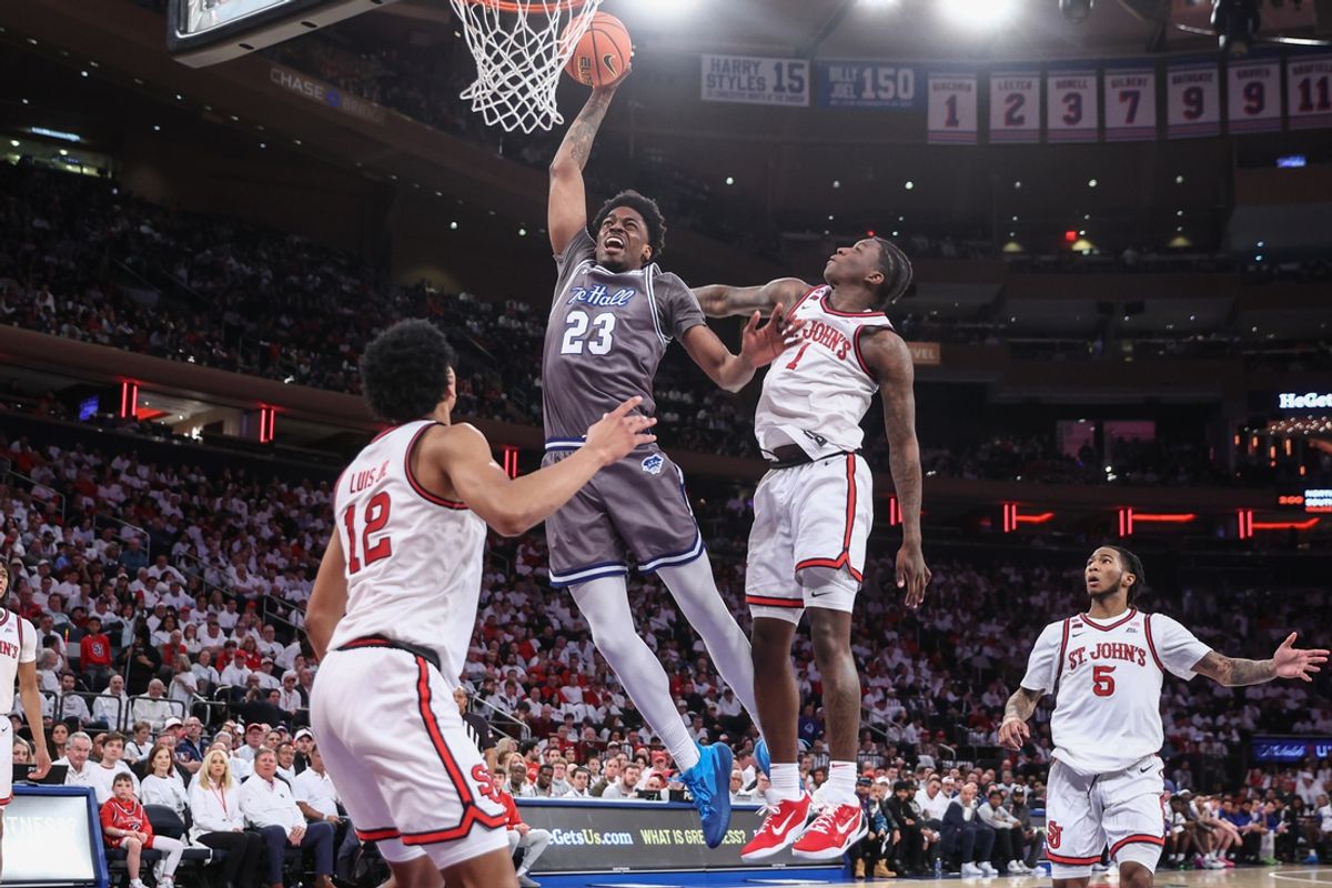 Mar 1, 2025; New York, New York, USA;  Seton Hall Pirates center Emmanuel Okorafor (23) drives past St. John's Red Storm guard Kadary Richmond (1) for a dunk in the first half at Madison Square Garden. Mandatory Credit: Wendell Cruz-Imagn Images