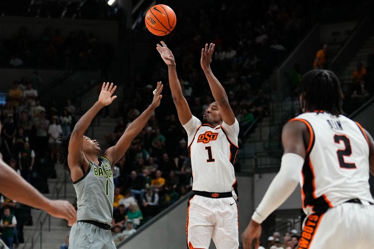 Mar 1, 2025; Waco, Texas, USA; Oklahoma State Cowboys guard Bryce Thompson (1) shoots as Baylor Bears guard Robert Wright III (1) defends during the first half at Paul and Alejandra Foster Pavilion. Mandatory Credit: Chris Jones-Imagn Images