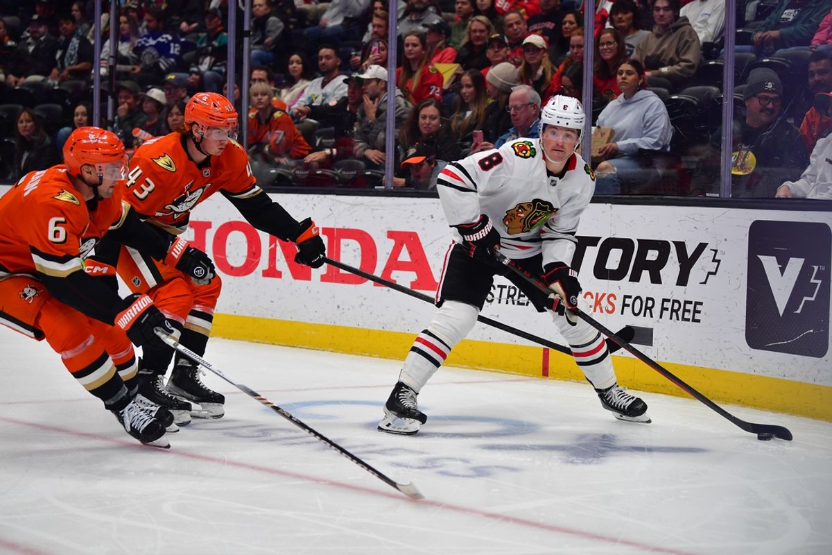Mar 1, 2025; Anaheim, California, USA; Chicago Blackhawks center Ryan Donato (8) moves the puck against Anaheim Ducks defenseman Brian Dumoulin (6) and defenseman Drew Helleson (43) during the first period at Honda Center. Mandatory Credit: Gary A. Vasquez-Imagn Images