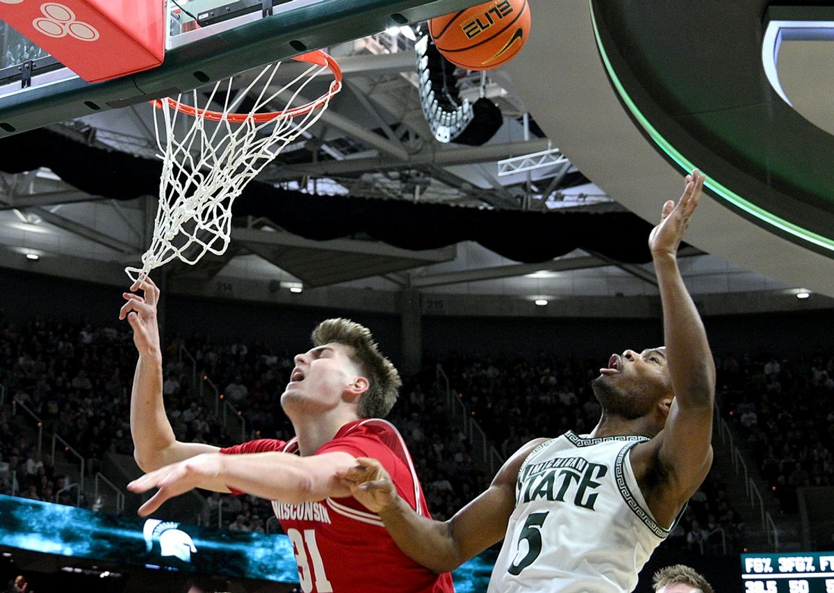Mar 2, 2025; East Lansing, Michigan, USA;  Wisconsin Badgers forward Nolan Winter (31) can’t get this shot to go while defended by Michigan State Spartans guard Tre Holloman (5) during the first half at Jack Breslin Student Events Center. Mandatory Credit: Dale Young-Imagn Images