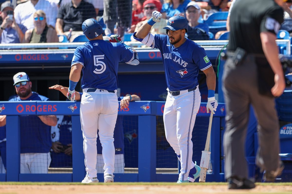 Mar 2, 2025; Dunedin, Florida, USA; Toronto Blue Jays outfielder Anthony Santander (25) congratulates outfielder Daulton Varsho (5) after hitting home run against the Philadelphia Phillies in the first inning during spring training at TD Ballpark. Mandatory Credit: Nathan Ray Seebeck-Imagn Images