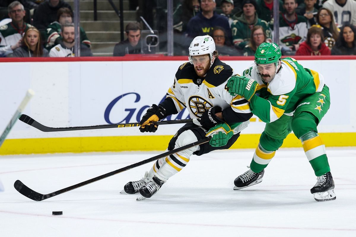 Mar 2, 2025; Saint Paul, Minnesota, USA; Boston Bruins right wing David Pastrnak (88) and Minnesota Wild defenseman Jake Middleton (5) compete for the puck during the first period at Xcel Energy Center. Mandatory Credit: Matt Krohn-Imagn Images