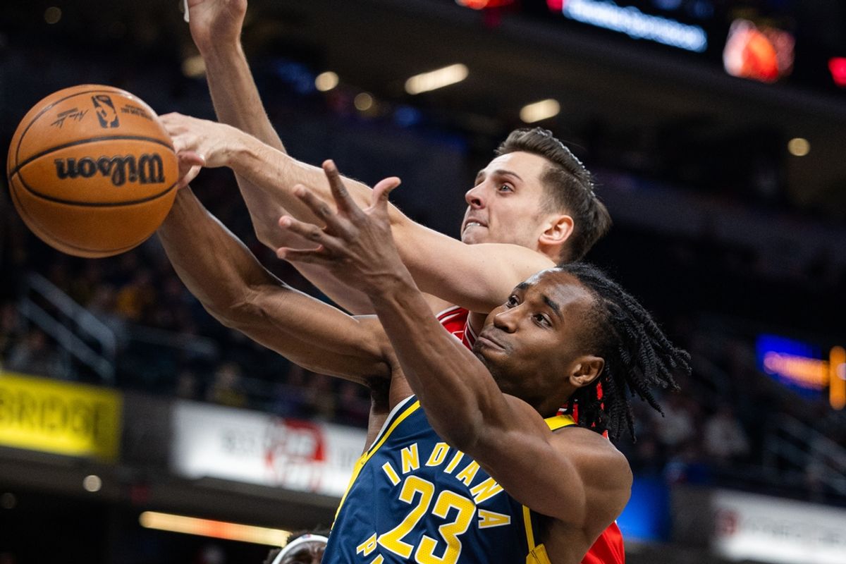 Mar 2, 2025; Indianapolis, Indiana, USA; Chicago Bulls forward Zach Collins (12) and Indiana Pacers forward Aaron Nesmith (23) fight for a rebound in the first half  at Gainbridge Fieldhouse. Mandatory Credit: Trevor Ruszkowski-Imagn Images