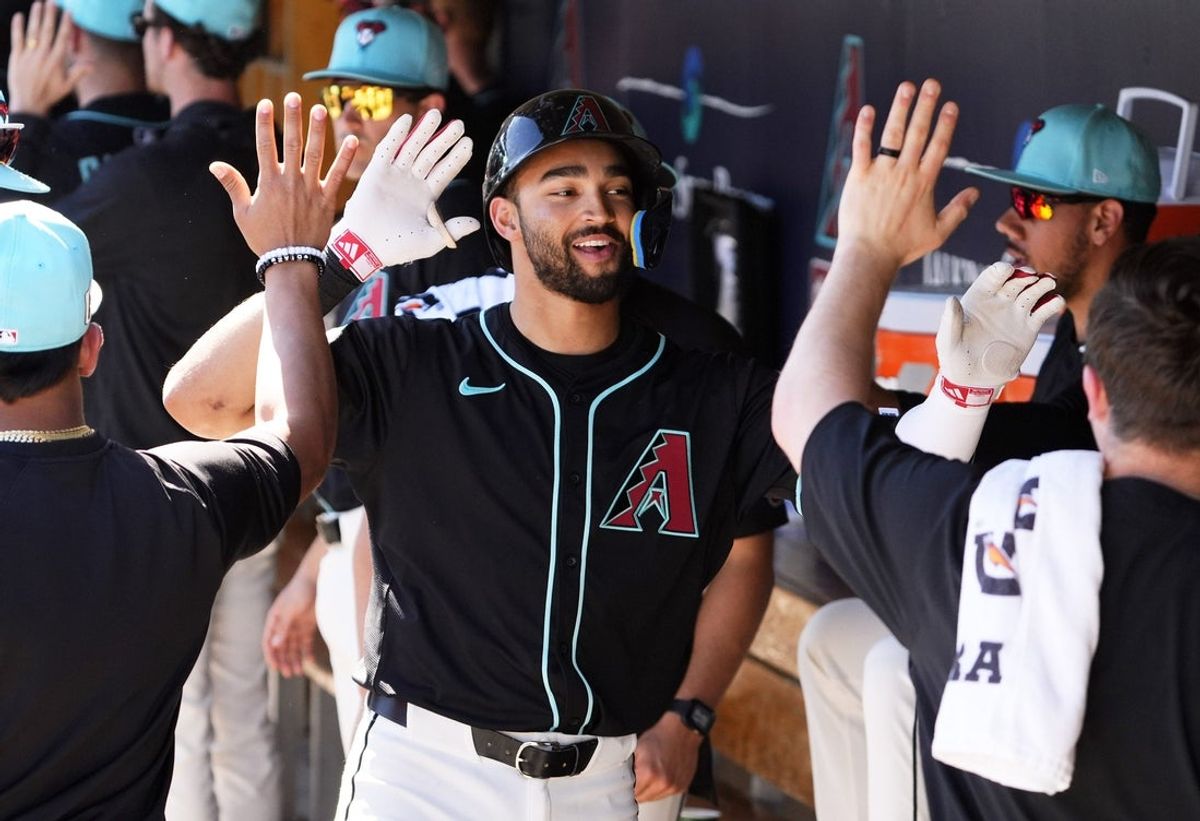 Arizona Diamondbacks Jordan Lawlar receives high-fives in the dugout after hitting a two-run home run off Milwaukee Brewers pitcher Tyler Alexander in the second inning of a spring training game at Salt River Fields at Talking Stick on Feb. 26, 2025.