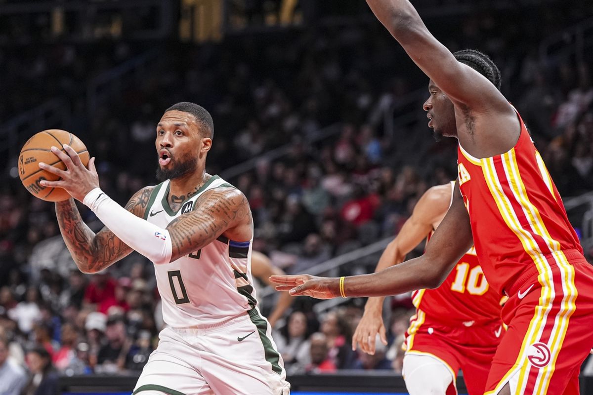 Mar 4, 2025; Atlanta, Georgia, USA; Milwaukee Bucks guard Damian Lillard (0) passes the ball in front of Atlanta Hawks center Clint Capela (15) during the first half at State Farm Arena. Mandatory Credit: Dale Zanine-Imagn Images