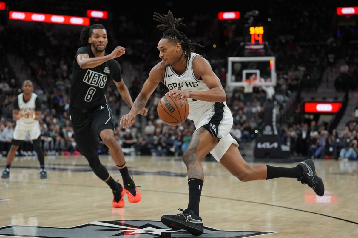 Mar 4, 2025; San Antonio, Texas, USA;  San Antonio Spurs guard Devin Vassell (24) dribbles past Brooklyn Nets forward Ziaire Williams (8) in the first half at Frost Bank Center. Mandatory Credit: Daniel Dunn-Imagn Images