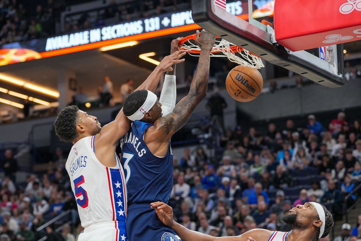 Mar 4, 2025; Minneapolis, Minnesota, USA; Minnesota Timberwolves forward Jaden McDaniels (3) dunks against the Philadelphia 76ers guard Quentin Grimes (5) in the second quarter at Target Center. Mandatory Credit: Brad Rempel-Imagn Images