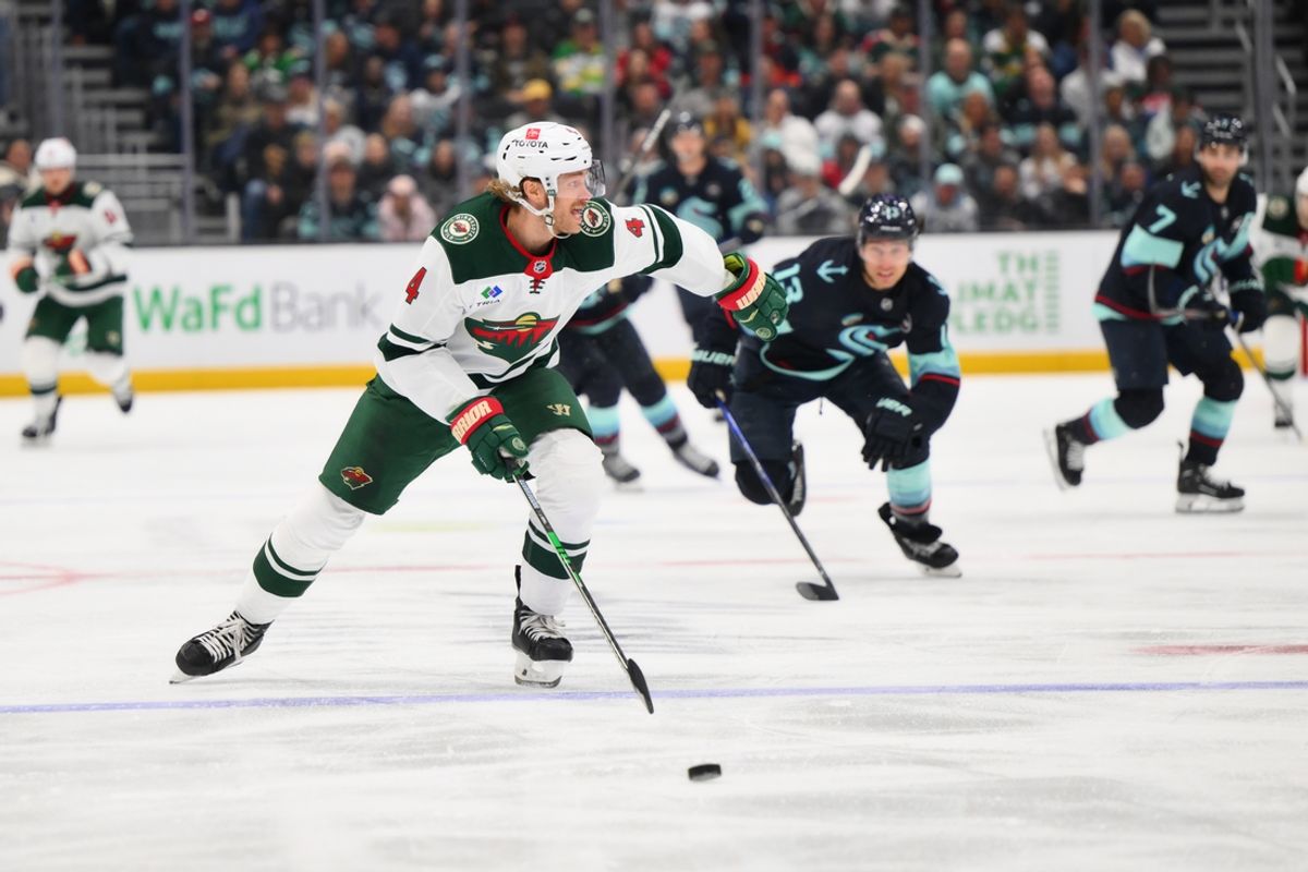 Mar 4, 2025; Seattle, Washington, USA; Minnesota Wild defenseman Jon Merrill (4) plays the puck during the third period against the Seattle Kraken at Climate Pledge Arena. Mandatory Credit: Steven Bisig-Imagn Images