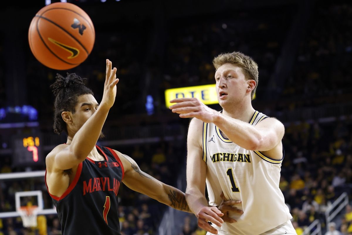 Mar 5, 2025; Ann Arbor, Michigan, USA;  Michigan Wolverines center Danny Wolf (1) passes on Maryland Terrapins guard Rodney Rice (1) in the first half at Crisler Center. Mandatory Credit: Rick Osentoski-Imagn Images