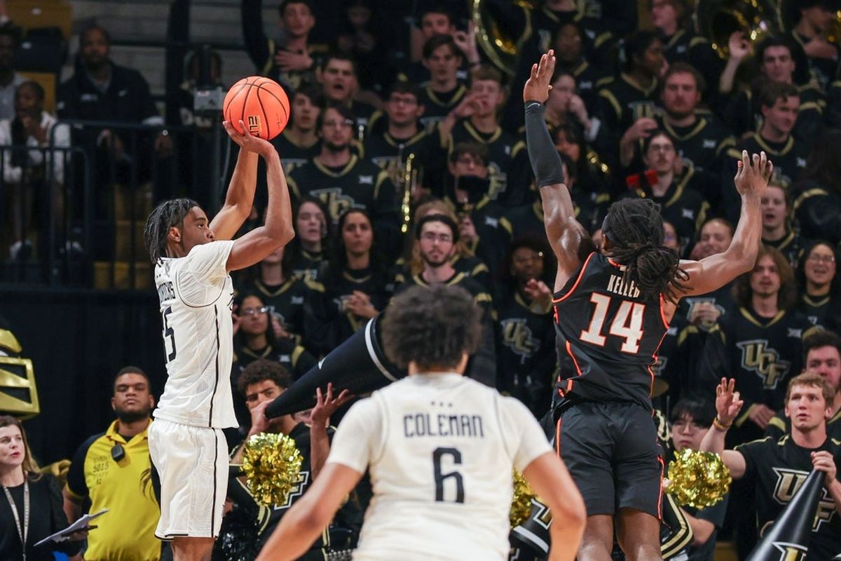 Mar 5, 2025; Orlando, Florida, USA; UCF Knights guard Tyler Hendricks (15) shoots the ball against Oklahoma State Cowboys guard Jamyron Keller (14) during the first half at Addition Financial Arena. Mandatory Credit: Mike Watters-Imagn Images
