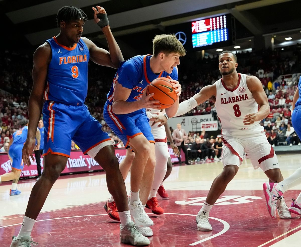 Mar 5, 2025; Tuscaloosa, AL, USA; Florida forward Alex Condon (21) grabs a rebound between Florida center Rueben Chinyelu (9) and Alabama guard Chris Youngblood (8) at Coleman Coliseum. Mandatory Credit: Gary Cosby Jr.-Tuscaloosa News