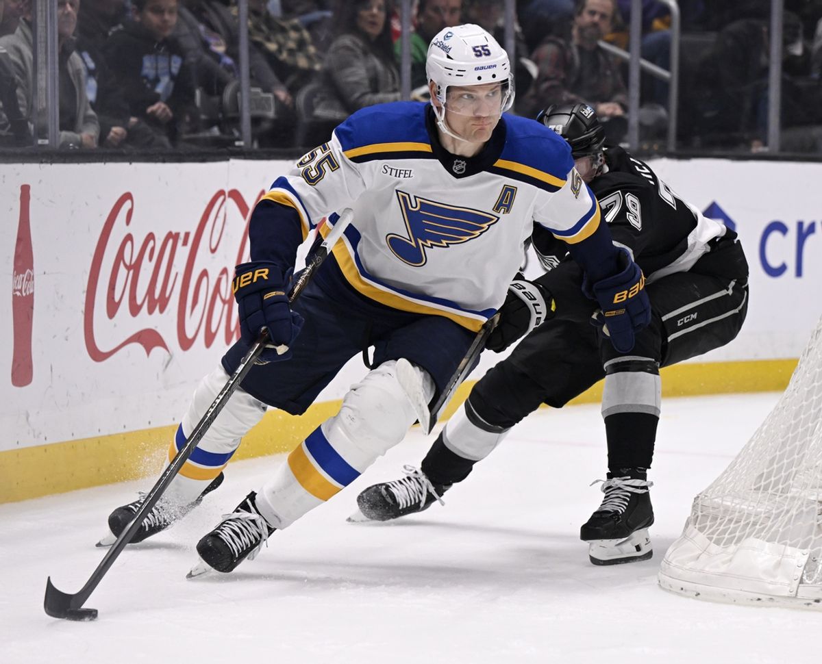 Mar 5, 2025; Los Angeles, California, USA;  St. Louis Blues defenseman Colton Parayko (55) controls the puck past Los Angeles Kings center Samuel Helenius (79) during the second period at Crypto.com Arena. Mandatory Credit: Alex Gallardo-Imagn Images