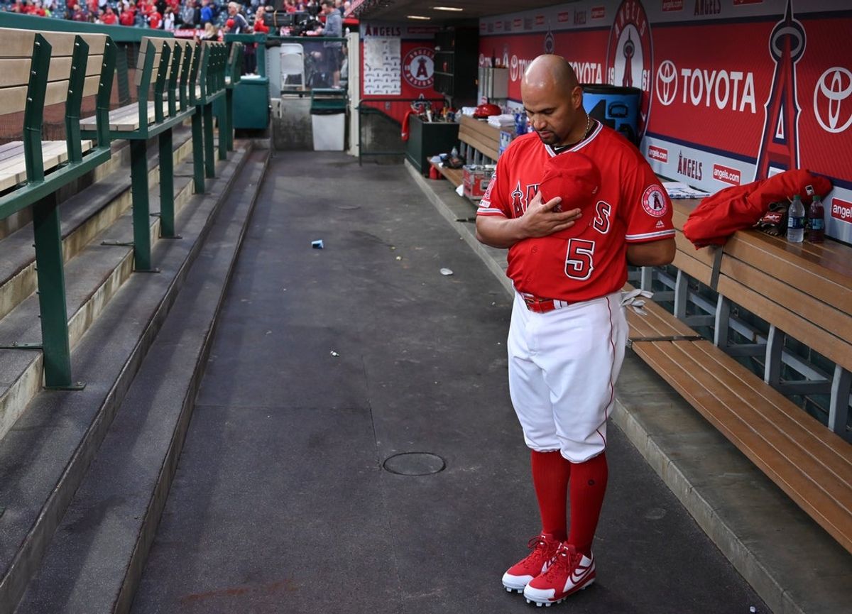 Los Angeles Angels first baseman Albert Pujols in the dugout during the national anthem before the start of a game against the Texas Rangers at Angel Stadium of Anaheim on Apr 5, 2019.