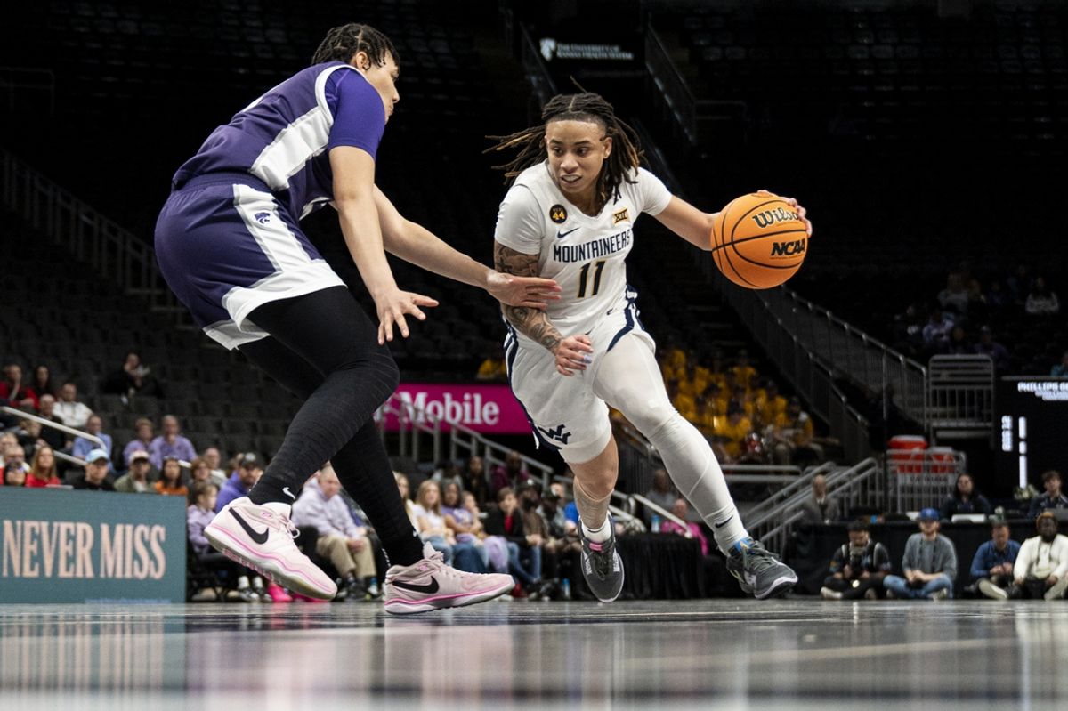 Mar 7, 2025; Kansas City, MO, USA; West Virginia Mountaineers guard JJ Quinerly (11) handles the ball while defended by Kansas State Wildcats forward Imani Lester (32) in the second quarter at T-Mobile Center. Mandatory Credit: Amy Kontras-Imagn Images