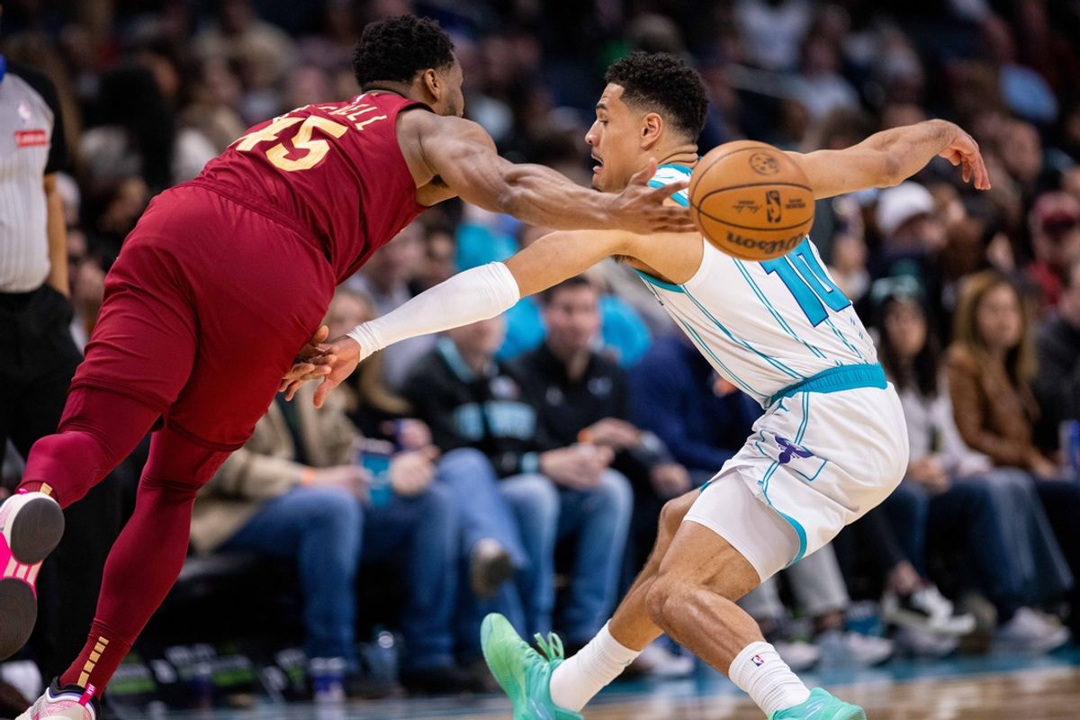Mar 7, 2025; Charlotte, North Carolina, USA; Cleveland Cavaliers guard Donovan Mitchell (45) passes the ball away against Cleveland Cavaliers guard Darius Garland (10) during the second quarter at Spectrum Center. Mandatory Credit: Scott Kinser-Imagn Images