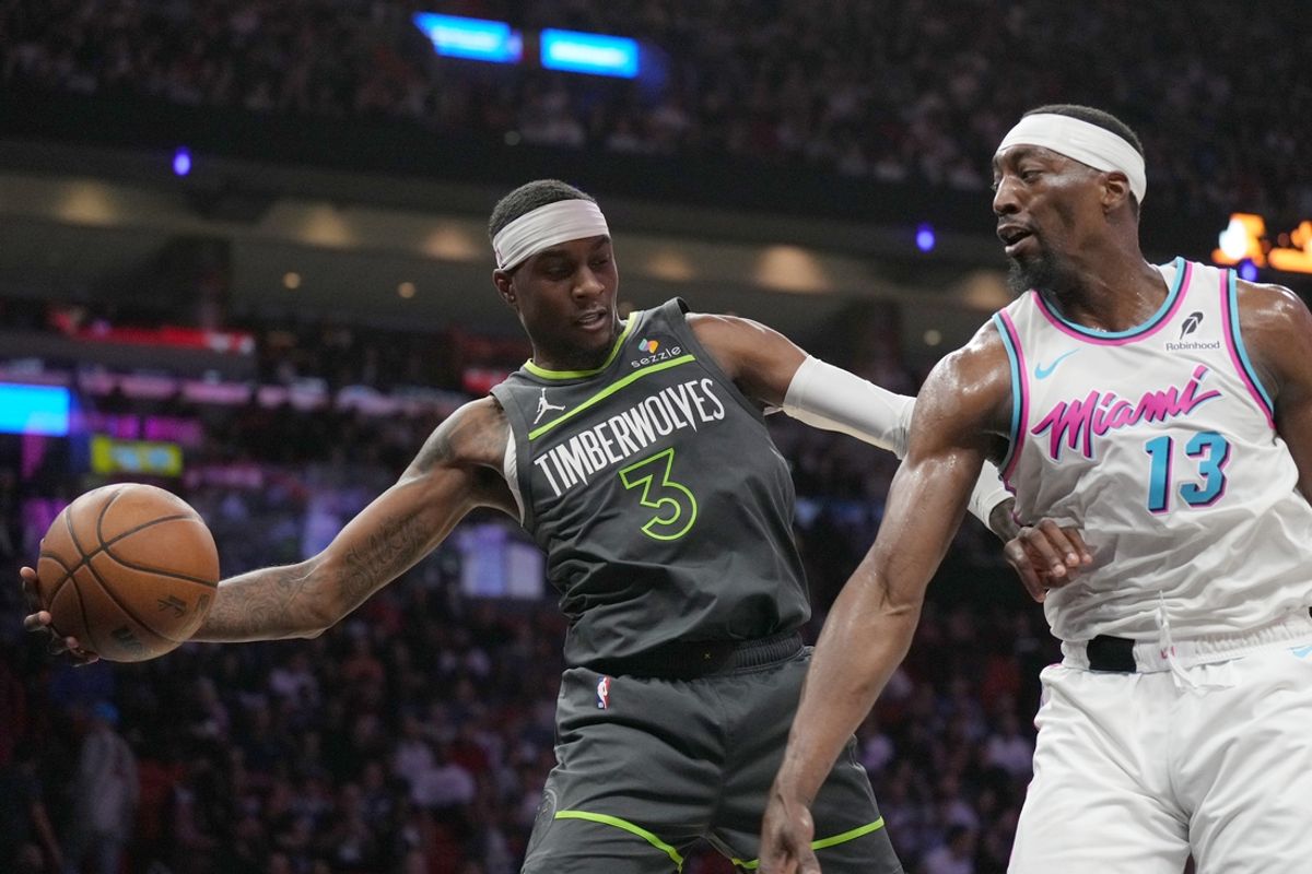 Mar 7, 2025; Miami, Florida, USA;  Minnesota Timberwolves forward Jaden McDaniels (3) saves the ball from going out of play as Miami Heat center Bam Adebayo (13) closes in during the first half at Kaseya Center. Mandatory Credit: Jim Rassol-Imagn Images