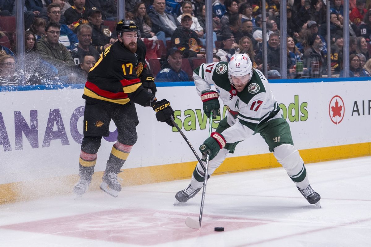 Mar 7, 2025; Vancouver, British Columbia, CAN; Vancouver Canucks defenseman Filip Hronek (17) stick checks Minnesota Wild forward Marcus Foligno (17) in the second period at Rogers Arena. Mandatory Credit: Bob Frid-Imagn Images