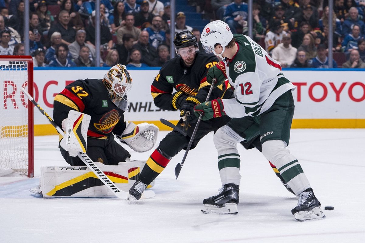 Mar 7, 2025; Vancouver, British Columbia, CAN; Vancouver Canucks goalie Kevin Lankinen (32) watches as defenseman Marcus Pettersson (29) checks Minnesota Wild forward Matt Boldy (12) in the second period at Rogers Arena. Mandatory Credit: Bob Frid-Imagn Images