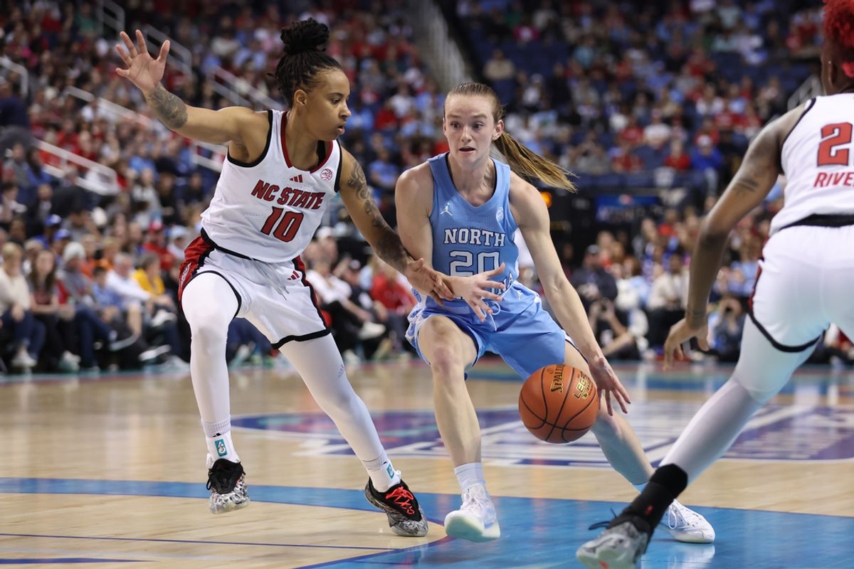 Mar 8, 2025; Greensboro, NC, USA; North Carolina Tar Heels guard Lexi Donarski (20) drives to the basket around NC State Wolfpack guard Aziaha James (10) during the second quarter at First Horizon Coliseum. Mandatory Credit: Cory Knowlton-Imagn Images