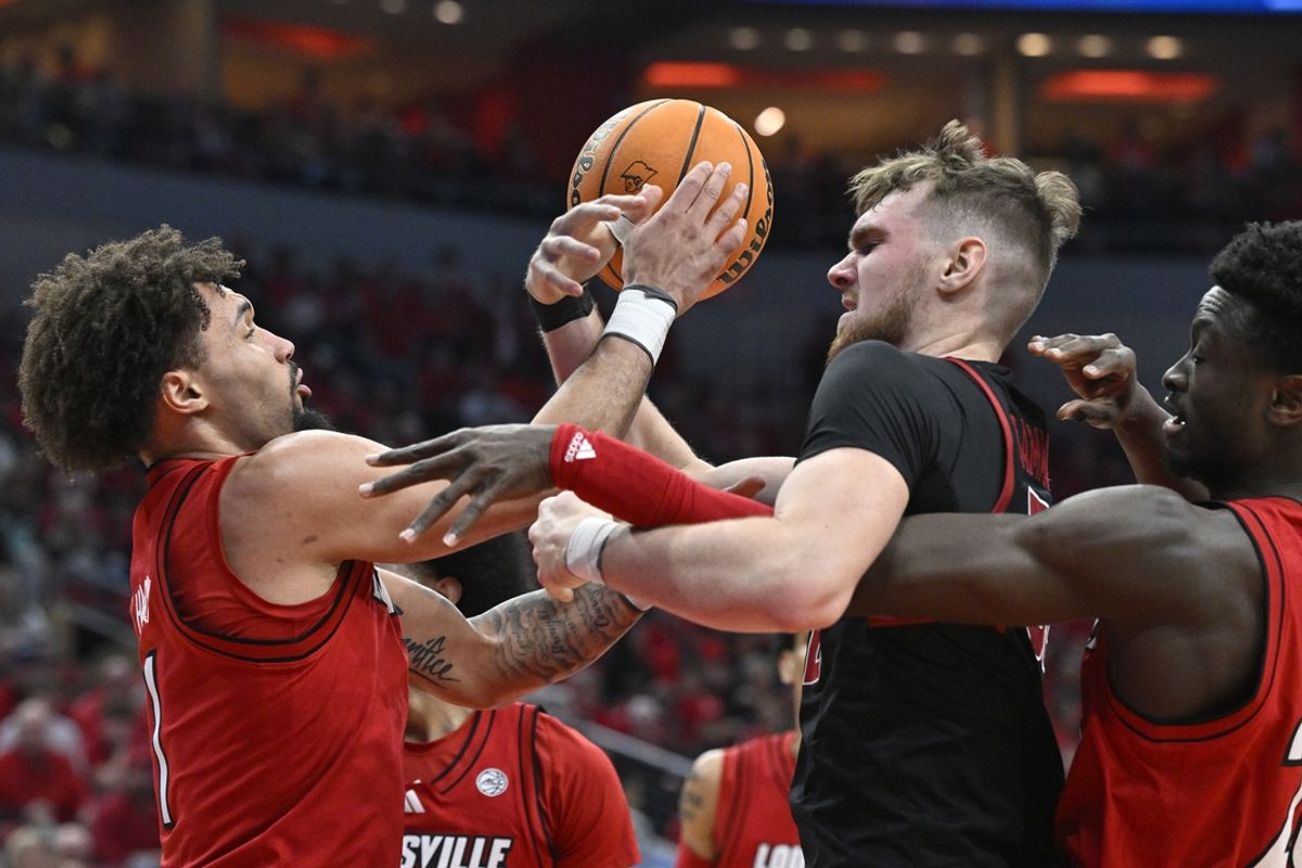 Mar 8, 2025; Louisville, Kentucky, USA;  Louisville Cardinals guard J'Vonne Hadley (1) and forward Aboubacar Traore (25) battle Stanford Cardinal forward Aidan Cammann (52) for a rebound during the first half at KFC Yum! Center. Mandatory Credit: Jamie Rhodes-Imagn Images