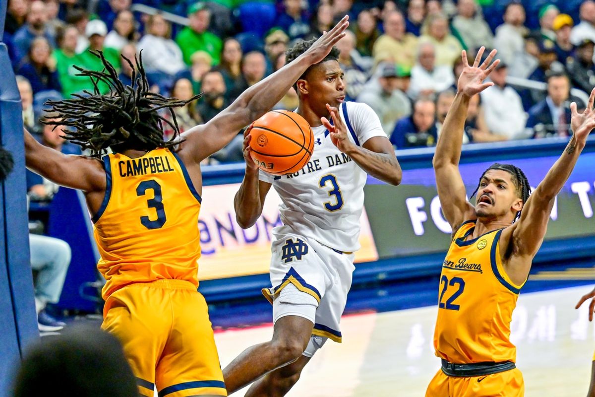 Mar 8, 2025; South Bend, Indiana, USA; Notre Dame Fighting Irish guard Markus Burton (3) passes the ball as Cal Bears guard DJ Campbell (3) and guard Christian Tucker (22) defend in the first half at the Purcell Pavilion. Mandatory Credit: Matt Cashore-Imagn Images