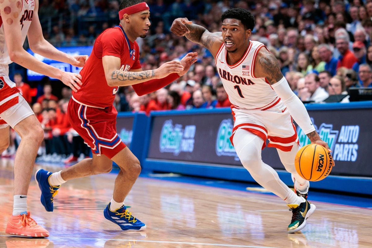 Mar 8, 2025; Lawrence, Kansas, USA; Arizona Wildcats guard Caleb Love (1) drives to the basket around Kansas Jayhawks guard Dajuan Harris Jr. (3) during the first half at Allen Fieldhouse. Mandatory Credit: William Purnell-Imagn Images