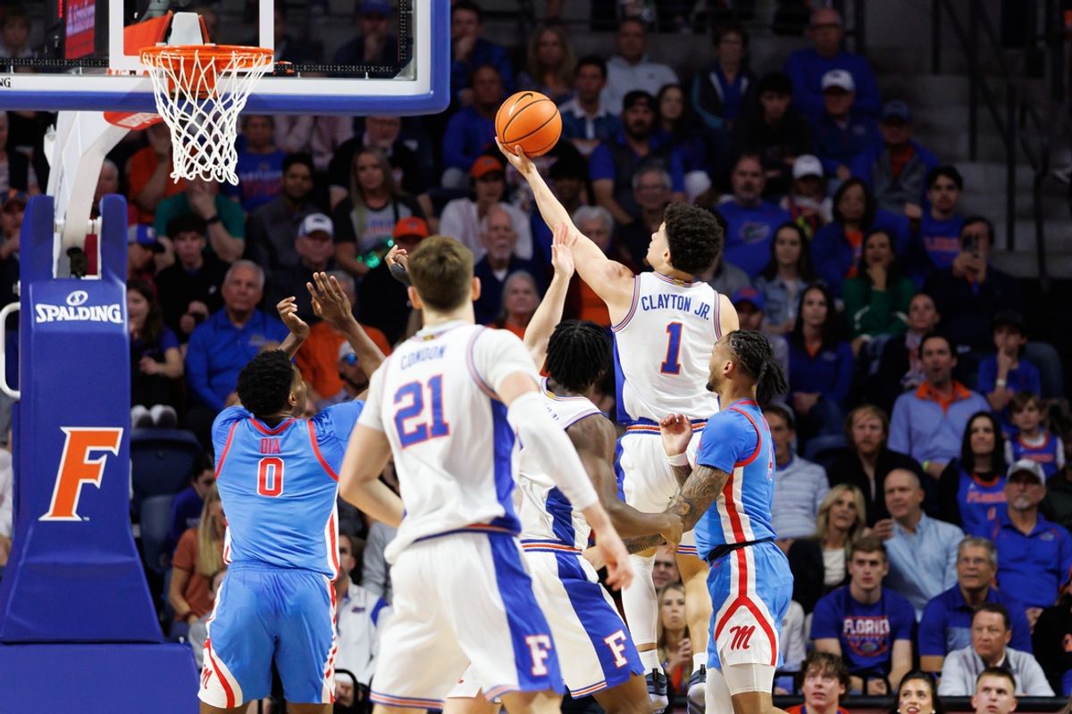Mar 8, 2025; Gainesville, Florida, USA; Florida Gators guard Walter Clayton Jr. (1) makes a layup over Mississippi Rebels forward Malik Dia (0) during the first half at Exactech Arena at the Stephen C. O'Connell Center. Mandatory Credit: Matt Pendleton-Imagn Images