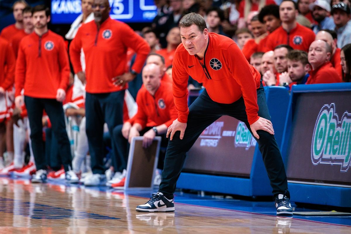 Mar 8, 2025; Lawrence, Kansas, USA; Arizona Wildcats coach Tommy Lloyd watches game play during the second half against the Kansas Jayhawks at Allen Fieldhouse. Mandatory Credit: William Purnell-Imagn Images