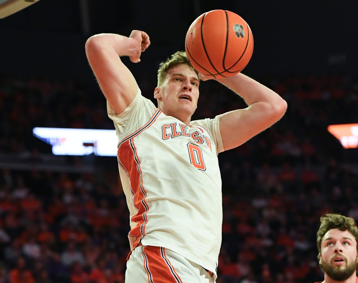 Mar 8, 2025; Clemson, SC, USA;  Clemson senior center Viktor Lakhin (0) dunks near Virginia Tech forward Ben Burnham (13)  during the first half at Littlejohn Coliseum in Clemson, S.C Saturday, March 8, 2025.  Mandatory Credit: Ken Ruinard/USA TODAY Network via Imagn Images