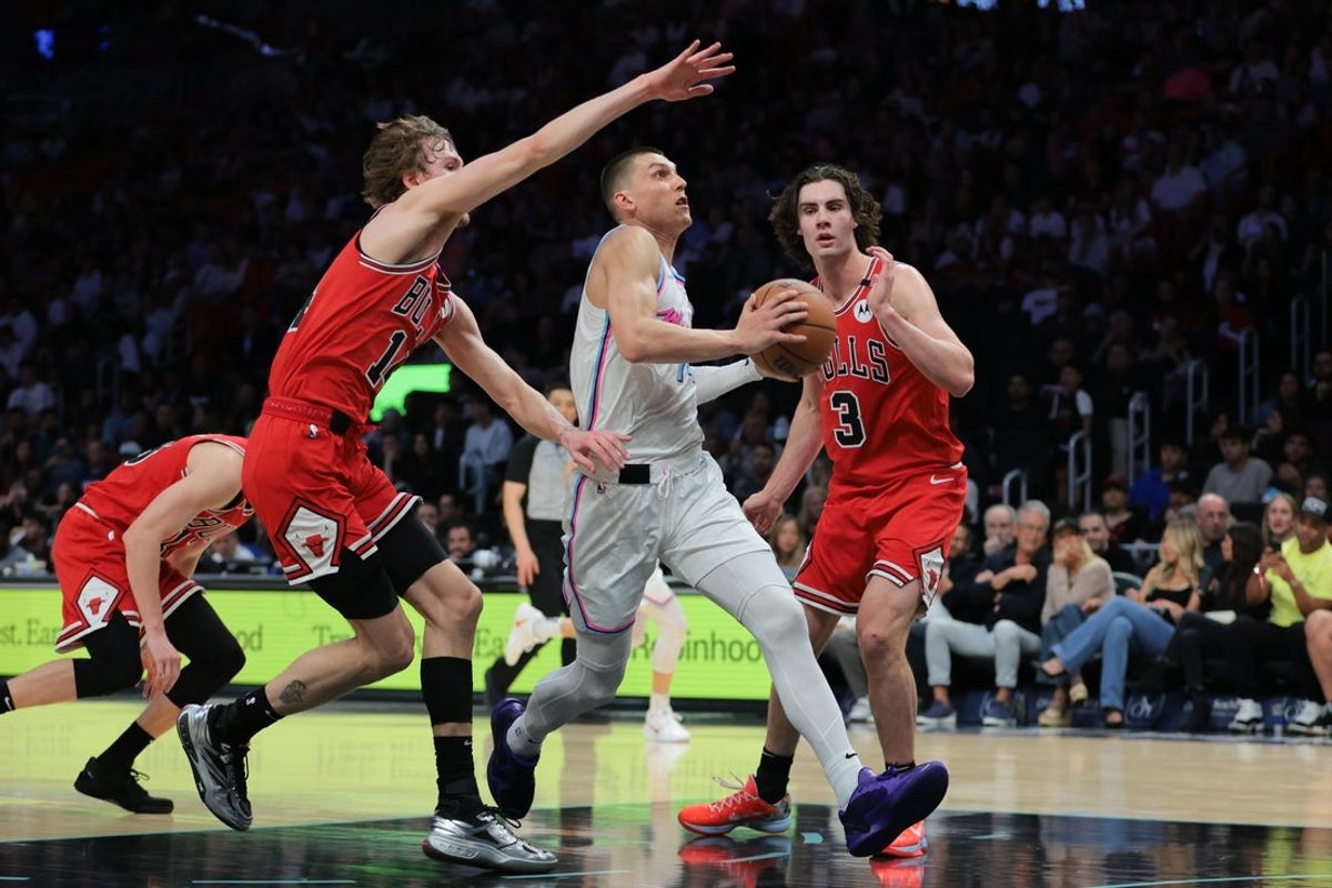 Mar 8, 2025; Miami, Florida, USA; Miami Heat guard Tyler Herro (14) drives to the basket past Chicago Bulls forward Matas Buzelis (14) and guard Josh Giddey (3) during the third quarter at Kaseya Center. Mandatory Credit: Sam Navarro-Imagn Images