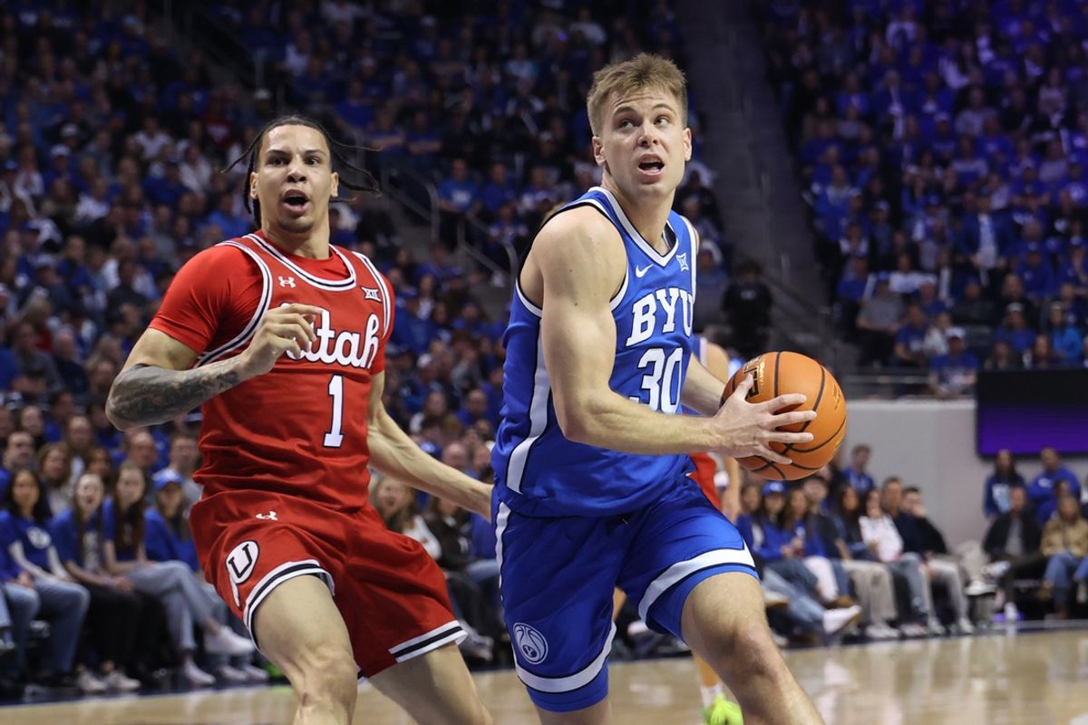 Mar 8, 2025; Provo, Utah, USA; Brigham Young Cougars guard Dallin Hall (30) drives against Utah Utes guard Miro Little (1) during the first half at Marriott Center. Mandatory Credit: Rob Gray-Imagn Images