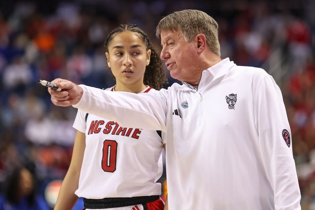 Mar 9, 2025; Greensboro, NC, USA;  NC State Wolfpack head coach Wes Moore talks with NC State Wolfpack guard Devyn Quigley (0) during the fourth quarter against Duke Blue Devils at First Horizon Coliseum. Mandatory Credit: Cory Knowlton-Imagn Images