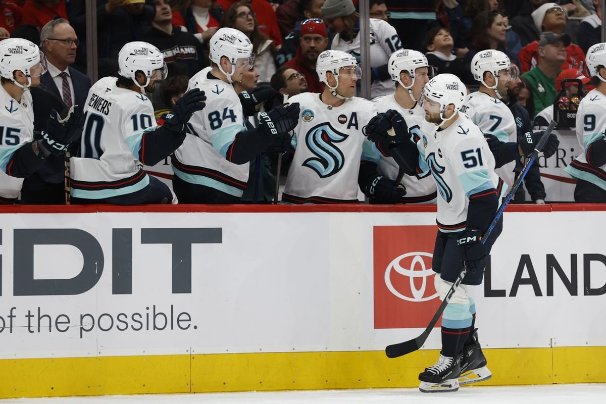 Seattle Kraken center Shane Wright (51) celebrates with teammates after scoring a goal against the Washington Capitals in the first period at Capital One Arena.