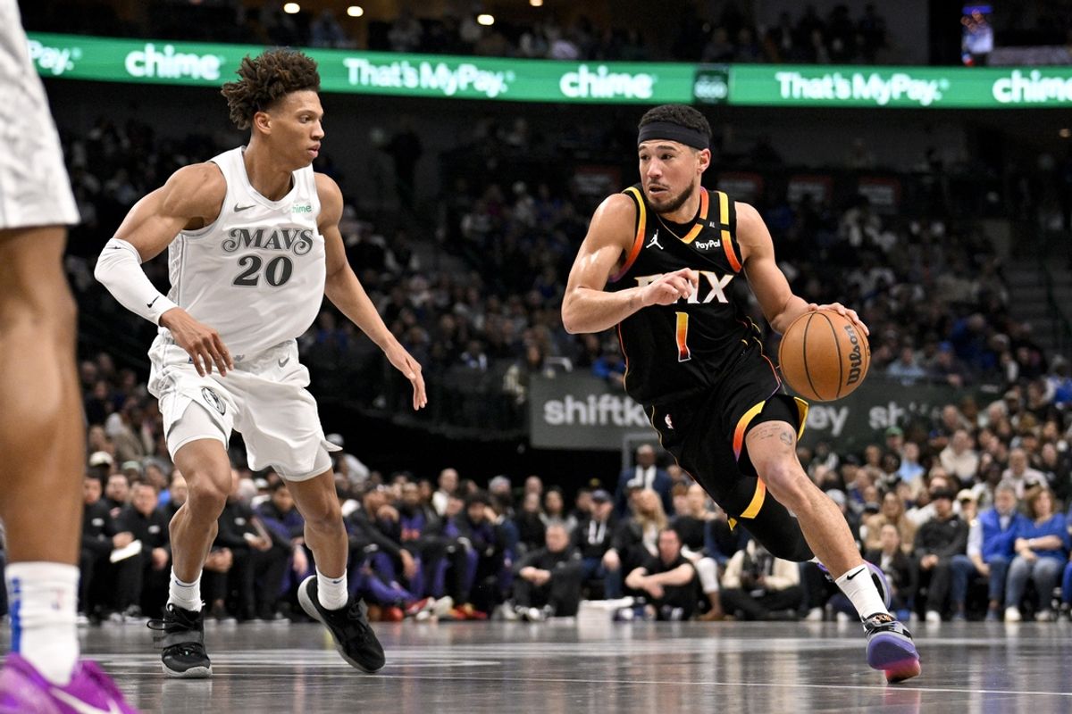 Mar 9, 2025; Dallas, Texas, USA; Phoenix Suns guard Devin Booker (1) drives to the basket past Dallas Mavericks forward Kessler Edwards (20) during the second quarter at the American Airlines Center. Mandatory Credit: Jerome Miron-Imagn Images