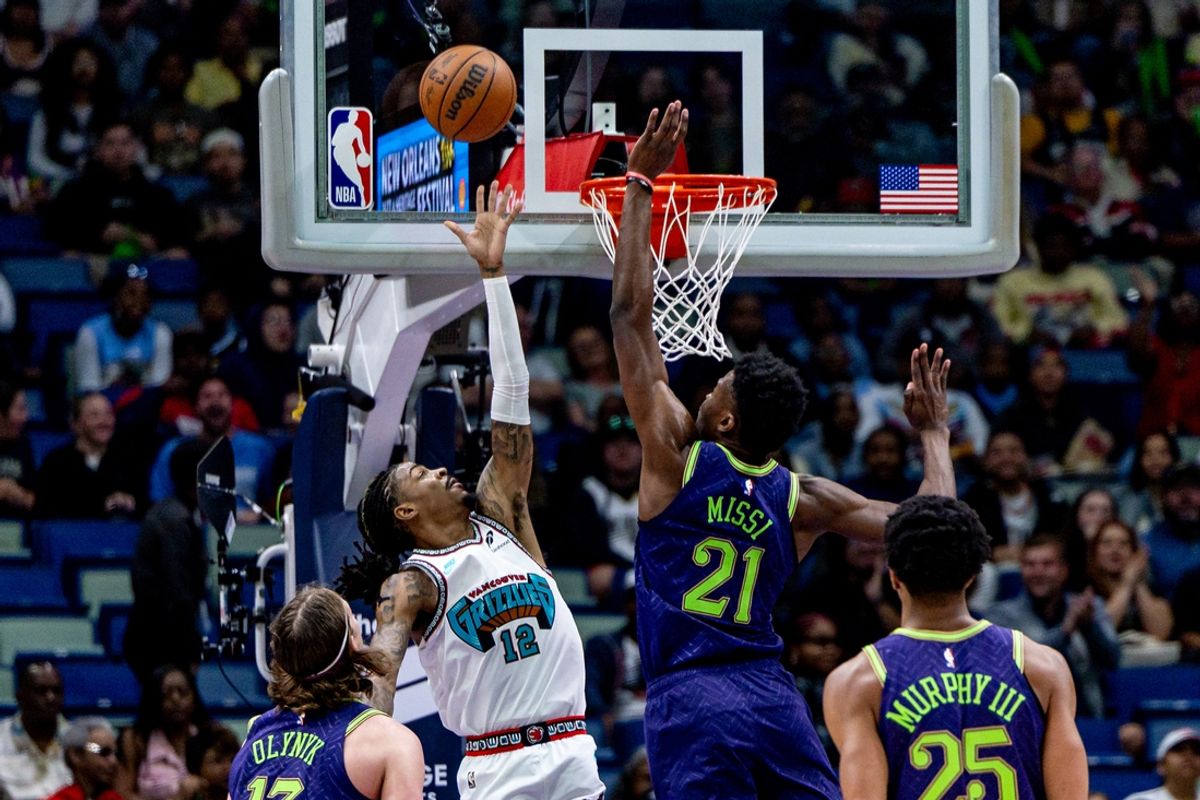 Mar 9, 2025; New Orleans, Louisiana, USA;  Memphis Grizzlies guard Ja Morant (12) misses a lay up over New Orleans Pelicans center Yves Missi (21) during the first half at Smoothie King Center. Mandatory Credit: Stephen Lew-Imagn Images