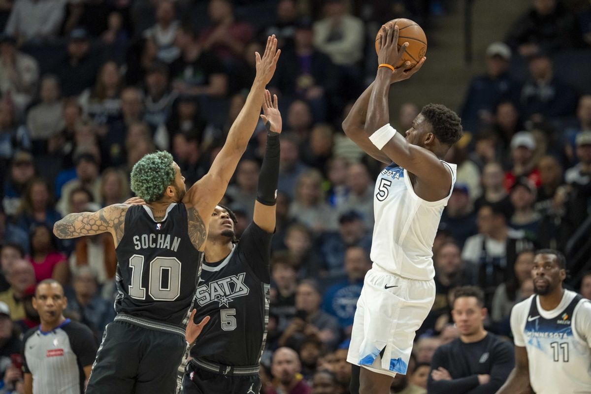 Mar 9, 2025; Minneapolis, Minnesota, USA; Minnesota Timberwolves guard Anthony Edwards (5) shoots the ball over San Antonio Spurs forward Jeremy Sochan (10) and San Antonio Spurs guard Stephon Castle (5) in the first half at Target Center. Mandatory Credit: Jesse Johnson-Imagn Images