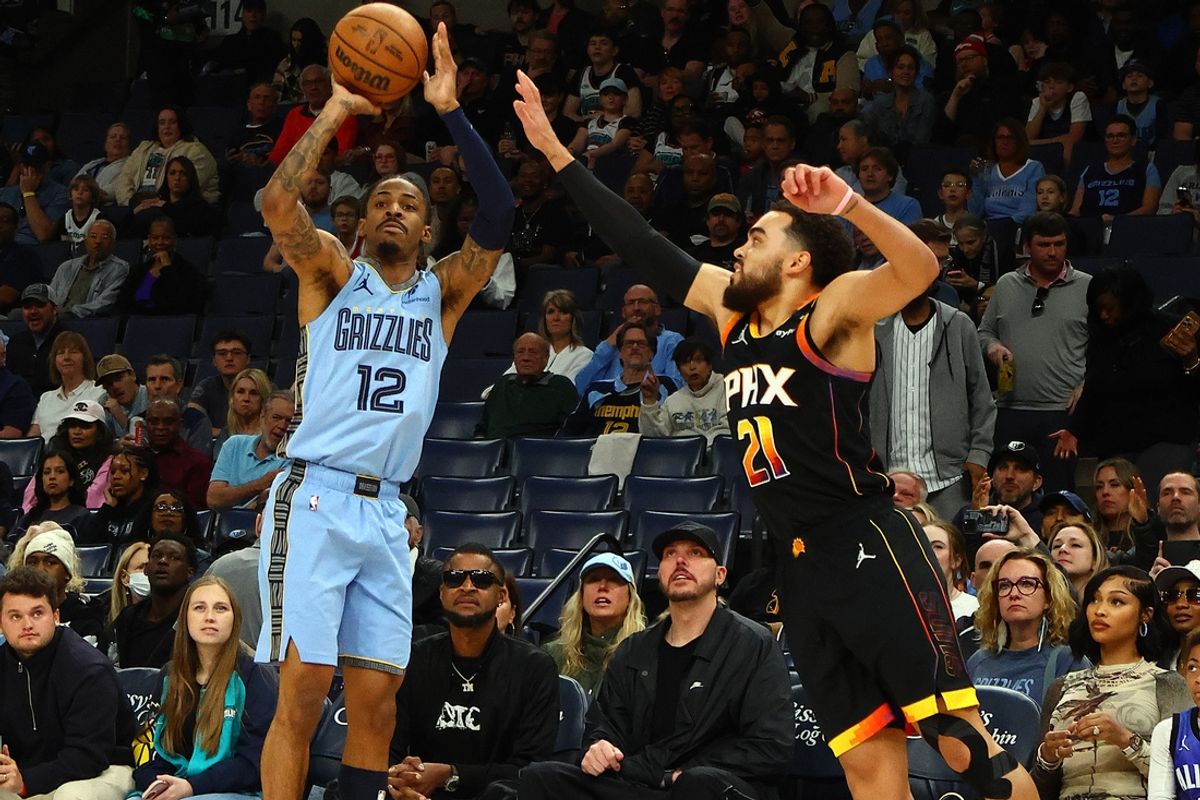 Mar 10, 2025; Memphis, Tennessee, USA; Memphis Grizzlies guard Ja Morant (12) shoots as Phoenix Suns guard Tyus Jones (21) defends during the first quarter at FedExForum. Mandatory Credit: Petre Thomas-Imagn Images