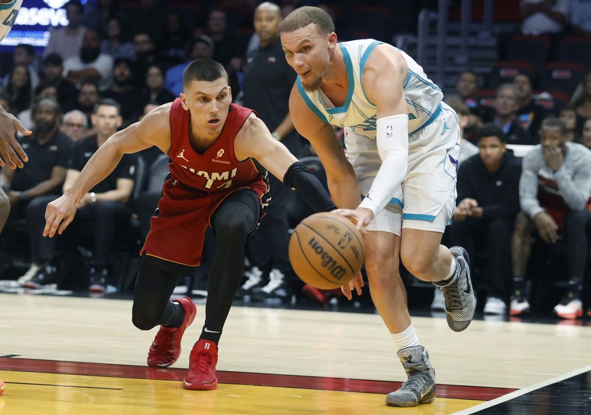 Mar 10, 2025; Miami, Florida, USA;  Charlotte Hornets guard Malachi Flynn (22) steals the ball from Miami Heat guard Tyler Herro (14) during the second half at Kaseya Center. Mandatory Credit: Rhona Wise-Imagn Images