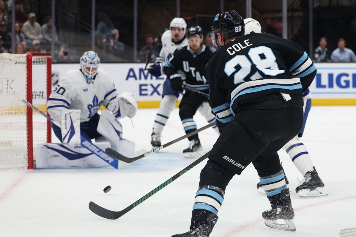 Mar 10, 2025; Salt Lake City, Utah, USA; Utah Hockey Club defenseman Ian Cole (28) takes a shot against the Toronto Maple Leafs goaltender Joseph Woll (60) during the first period at Delta Center. Mandatory Credit: Rob Gray-Imagn Images