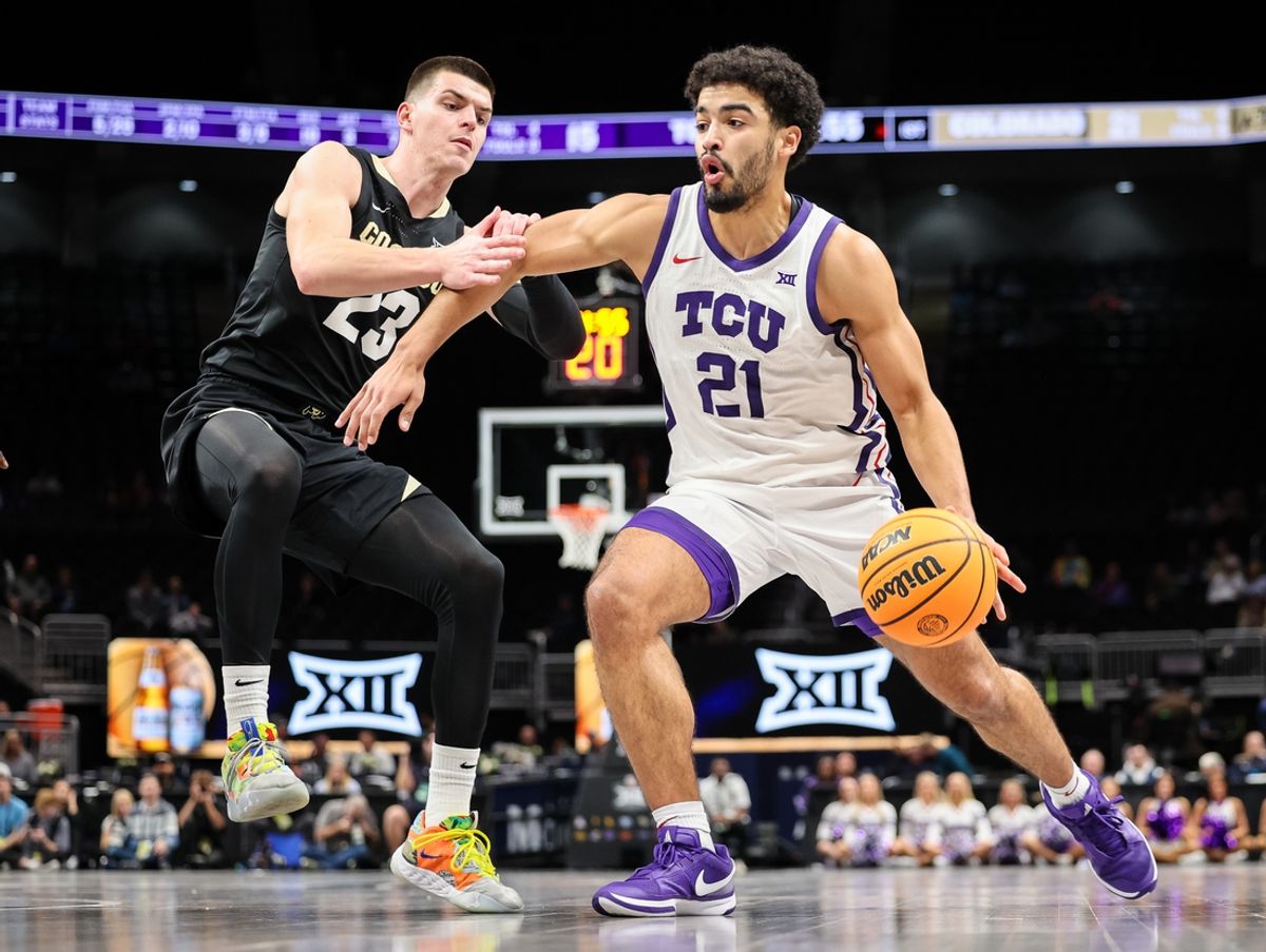Mar 11, 2025; Kansas City, MO, USA; TCU Horned Frogs guard Noah Reynolds (21) drives to the basket around Colorado Buffaloes forward Andrej Jakimovski (23) during the first half at T-Mobile Center. Mandatory Credit: William Purnell-Imagn Images