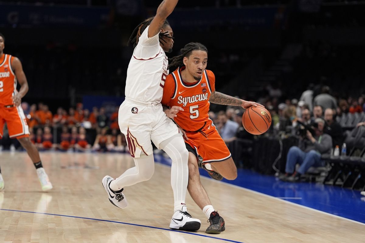 Mar 11, 2025; Charlotte, NC, USA; Syracuse Orange guard Jaquan Carlos (5) handles the ball defended by Florida State Seminoles guard Daquan Davis (5) during the first half at Spectrum Center. Mandatory Credit: Jim Dedmon-Imagn Images