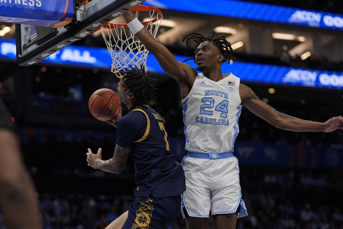 Mar 12, 2025; Charlotte, NC, USA; North Carolina Tar Heels forward Jae'Lyn Withers (24) jumps for the block on the shot by Notre Dame Fighting Irish forward Tae Davis (7) during the first half at Spectrum Center. Mandatory Credit: Jim Dedmon-Imagn Images