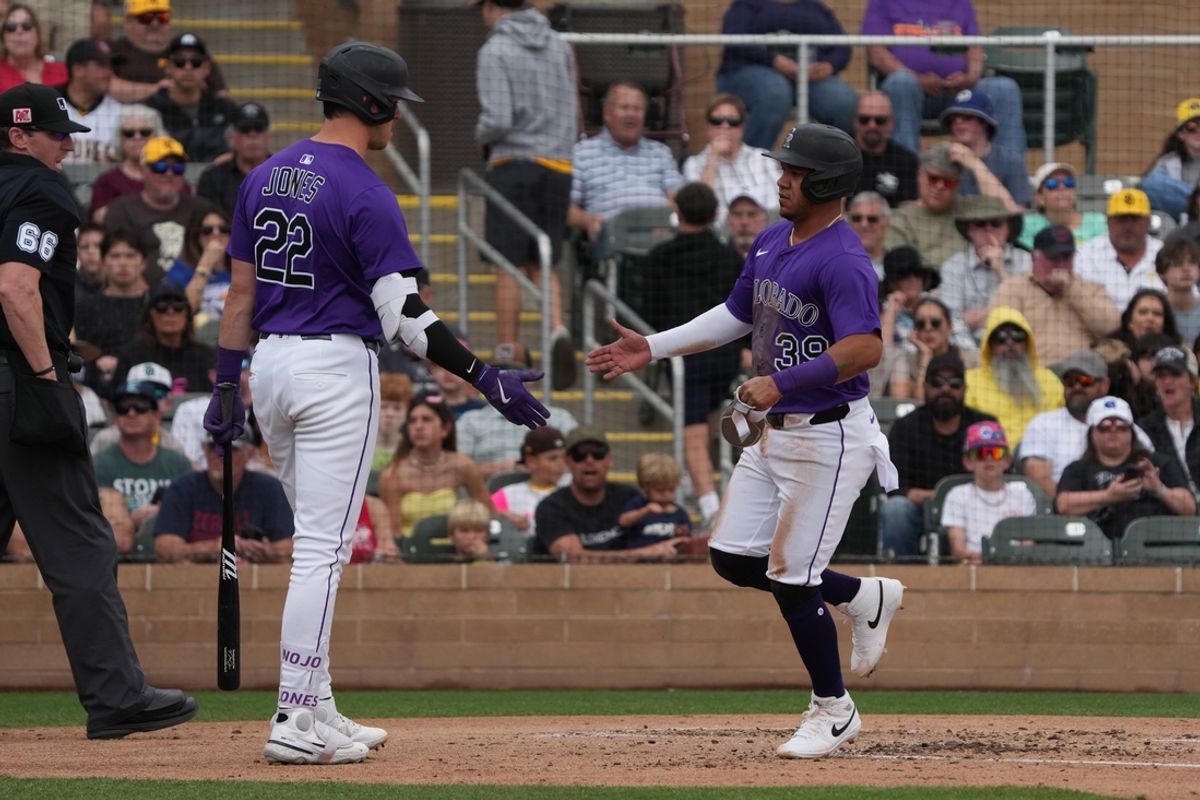 Mar 12, 2025; Salt River Pima-Maricopa, Arizona, USA; Colorado Rockies second base Thairo Estrada (39) celebrates with outfielder Nolan Jones (22) after scoring on a wild pitch against the San Diego Padres in the second inning at Salt River Fields at Talking Stick. Mandatory Credit: Rick Scuteri-Imagn Images