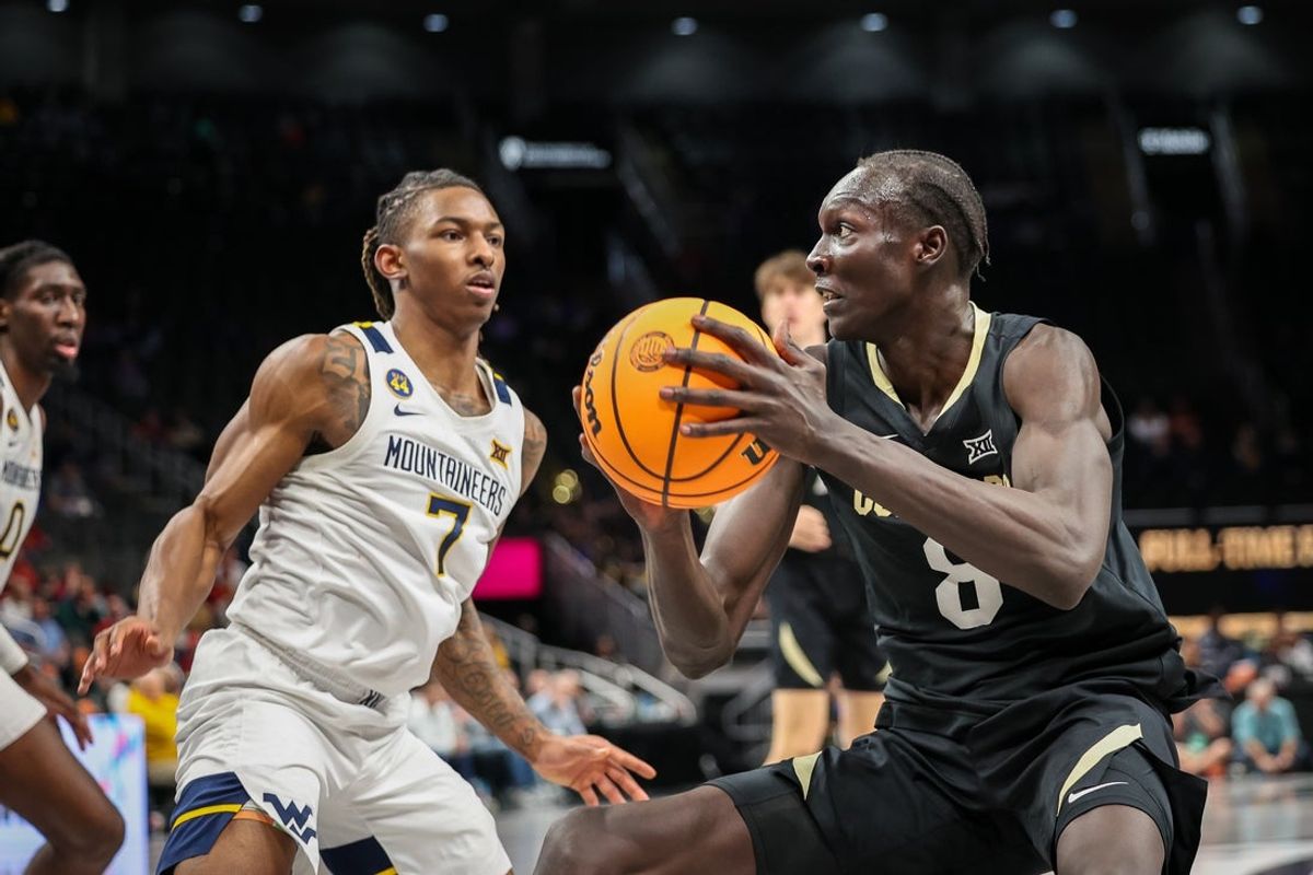 Mar 12, 2025; Kansas City, MO, USA; Colorado Buffaloes forward Bangot Dak (8) drives to the basket around West Virginia Mountaineers guard Javon Small (7) during the second half at T-Mobile Center. Mandatory Credit: William Purnell-Imagn Images