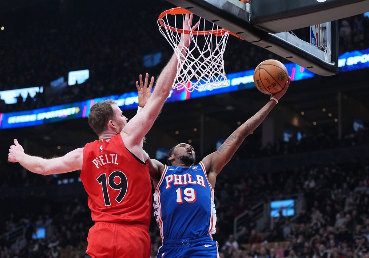 Mar 12, 2025; Toronto, Ontario, CAN; Philadelphia 76ers forward Justin Edwards (19) drives  to the basket as Toronto Raptors center Jakob Poeltl (19) tries to defend during the first quarter at the Scotiabank Arena. Mandatory Credit: Nick Turchiaro-Imagn Images